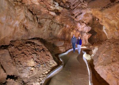 couple holding hands walking in cave