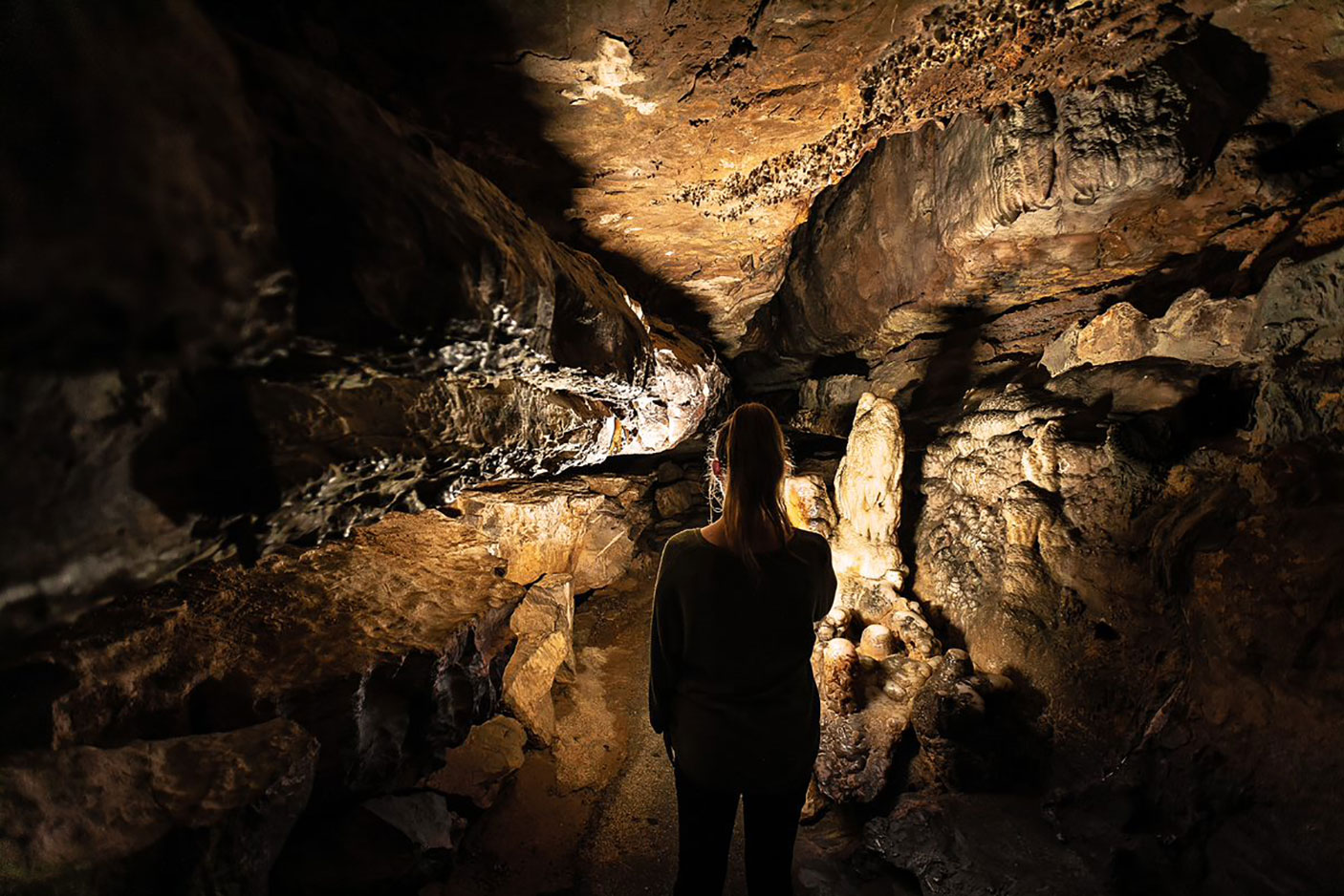 girl walking through cave