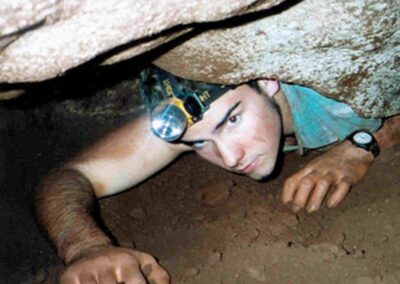 man crawling through cave