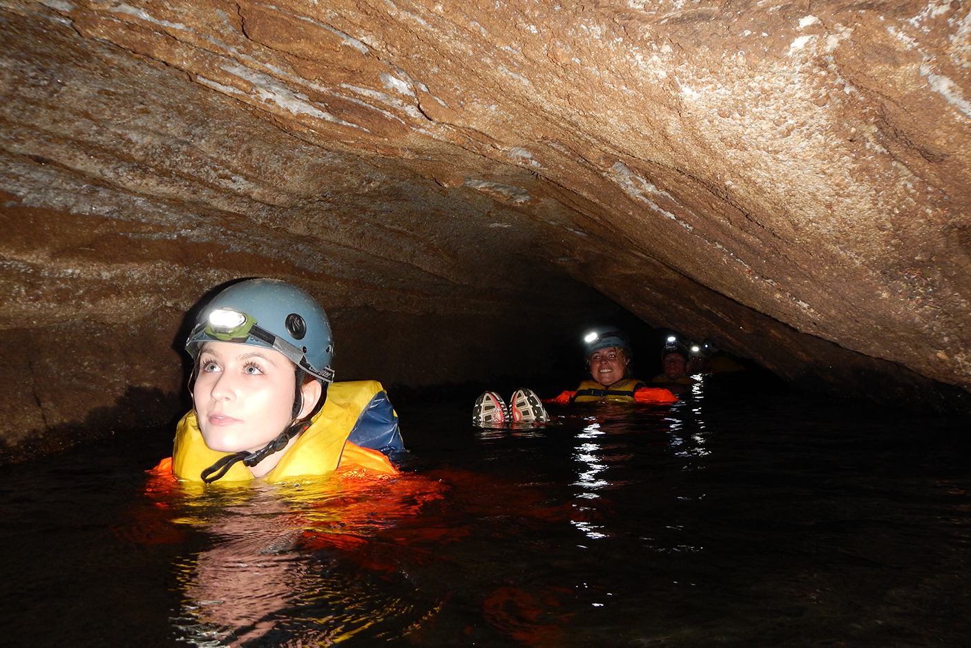 2 girls swimming through cave