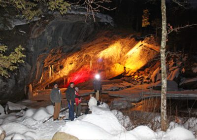 People with snow shoes looking at the cave