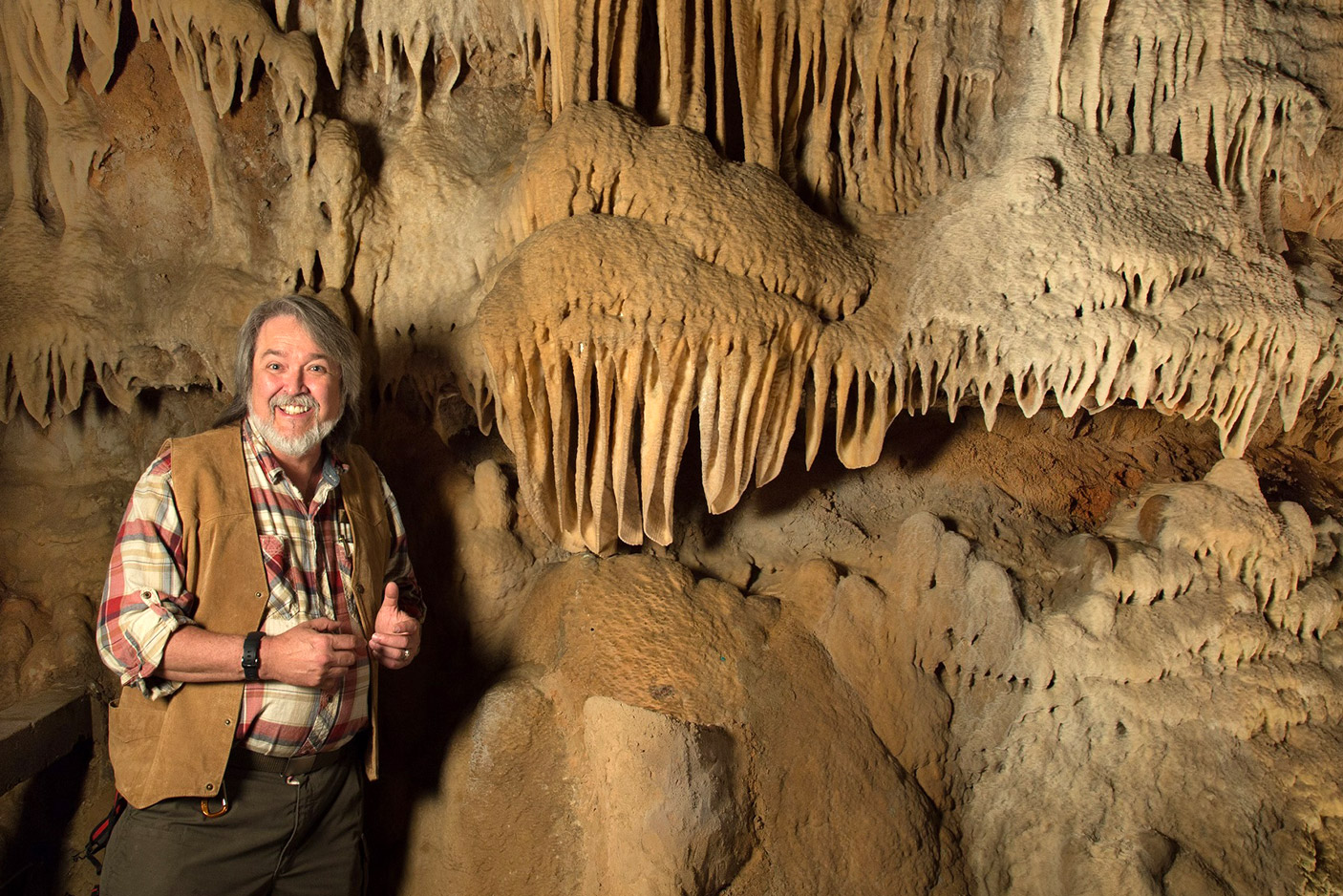 man posing with cave formations